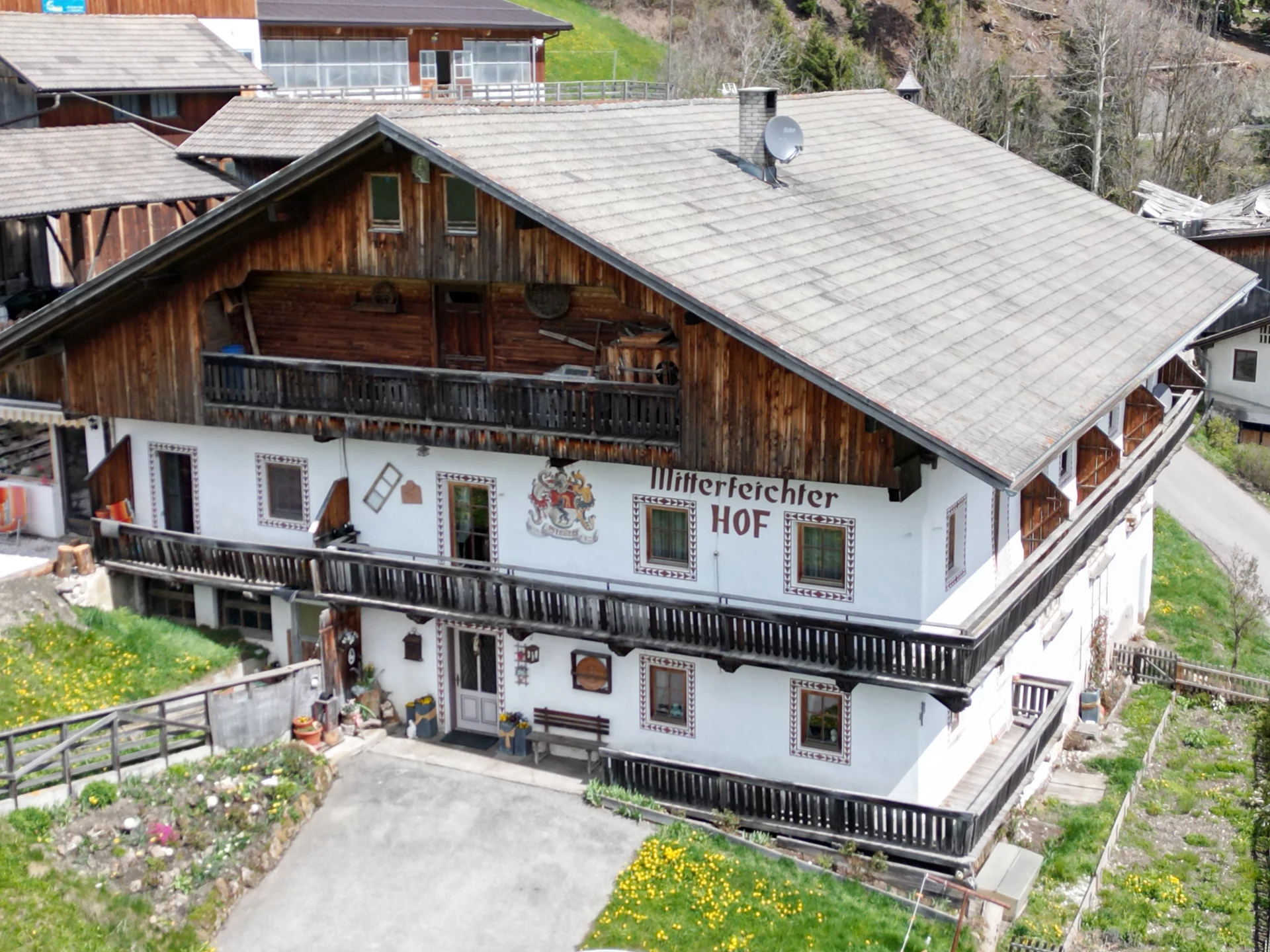 Der Mitterfeichterhof mit Holzfassade, Balkonen und bemalter Fassade