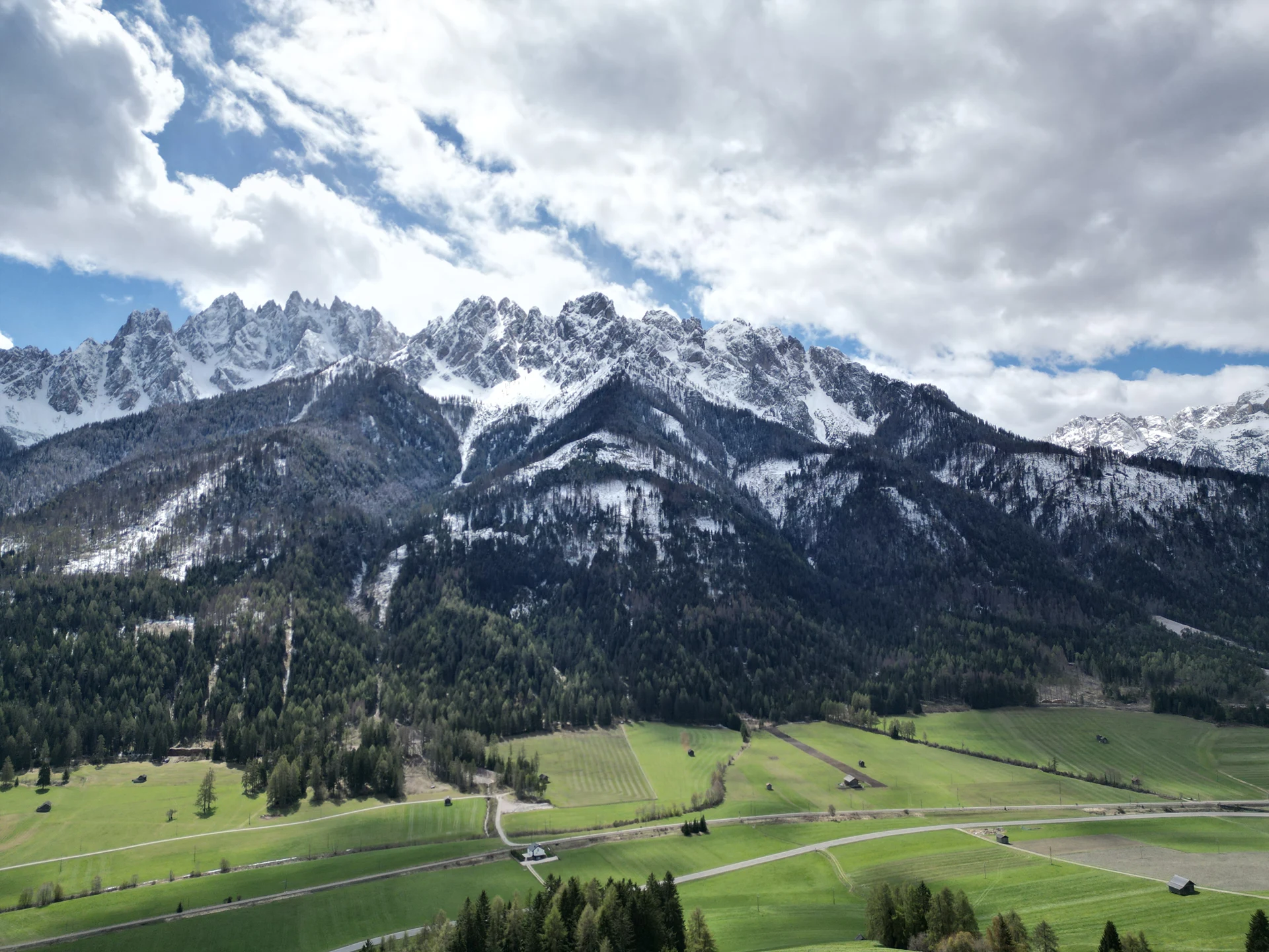 Verschneites Haunoldmassiv über den Wiesen bei Toblach